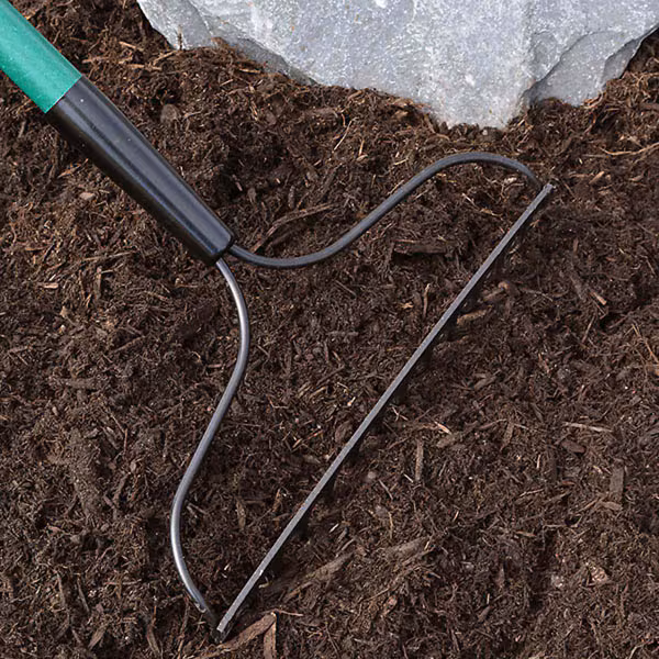 raking composted bark mulch to fluff it up