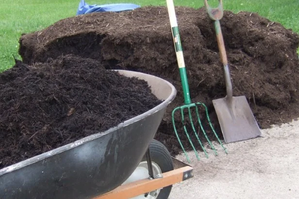 landscaping tool learning up on a pile of composted bark mulch